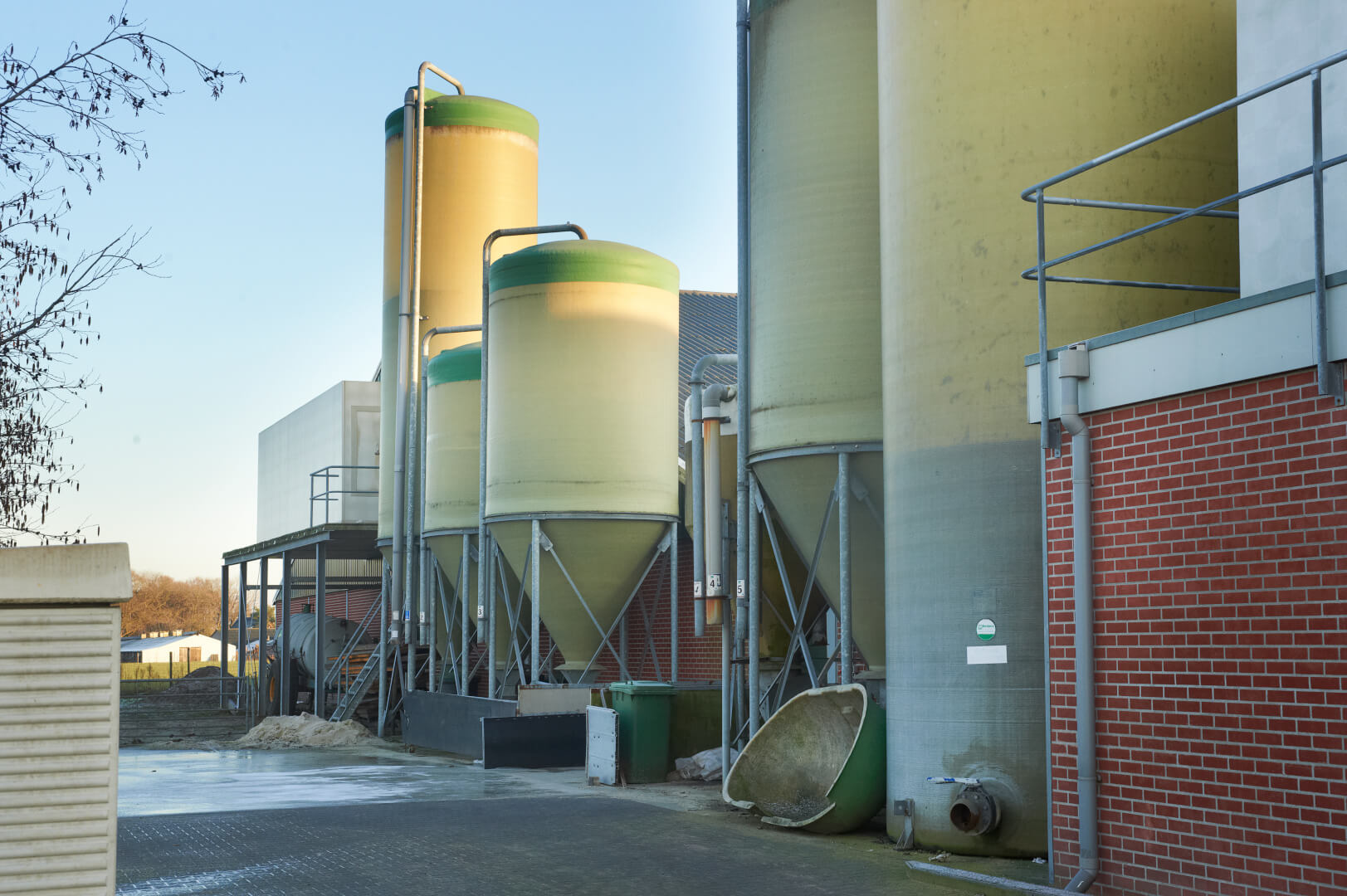 Achter de stallen is e een één oogopslag veel te zien. De Luchter, voersilo's en opslag van spuiwater van de luchtwassers. Het erf is keurig verhard en alles staat netjes in lijn. De gereinigde kadaverkap had volgens Bankers wel wat beter opgeborgen kunnen worden. 