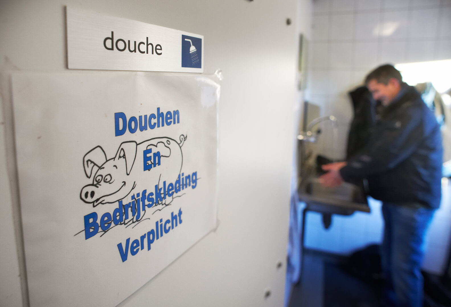 Een deur geeft toegang tot de stallen. Dat is die naar de hygiënesluis. Handen wassen voordat je de dierverblijven in gaat is ook een aanrader. 