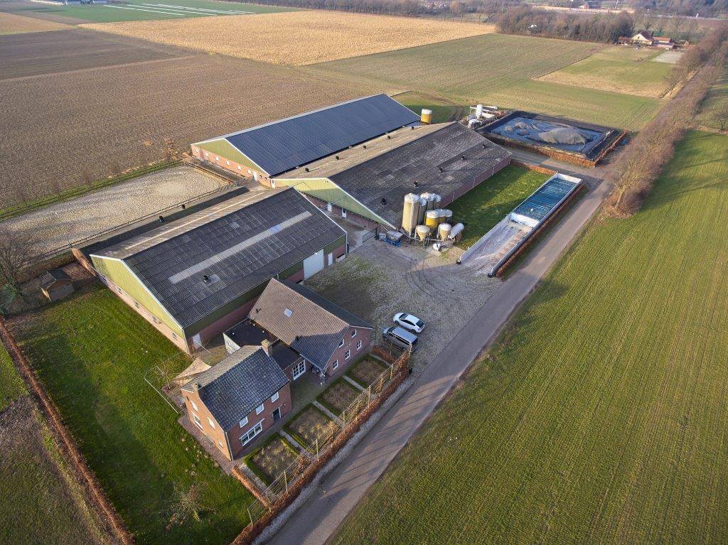 Het bedrijf van Robert van Baal met in het midden van de foto de zeugenstal en daarvoor naast de silo’s de vleesvarkensstal. 