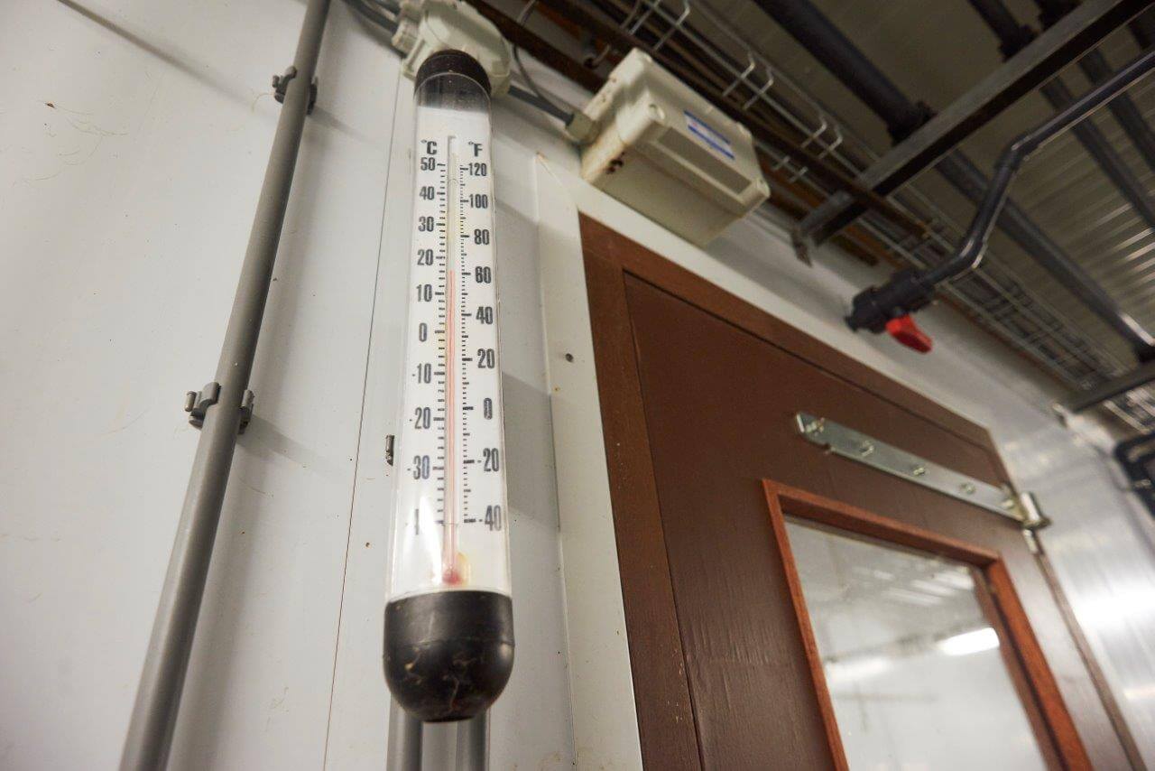 Een vluchtige blik op deze thermometer levert Vissers direct informatie over temperatuur van lucht die via het grondkanaal onder de voerpad de afdeling in stroomt. 