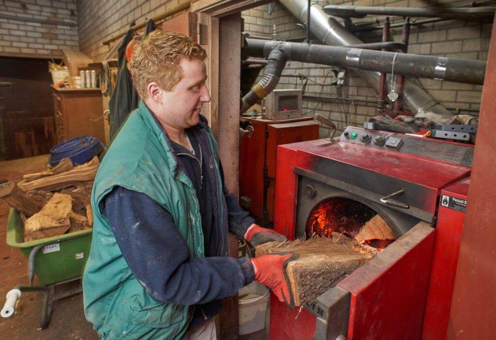 Voor de verwarming zijn twee kachels in gebruik. De achterste kachel op de foto werkt automatisch met houtpallets. De voorste is in gebruik als het koud is en moet met de hand worden gevuld. 