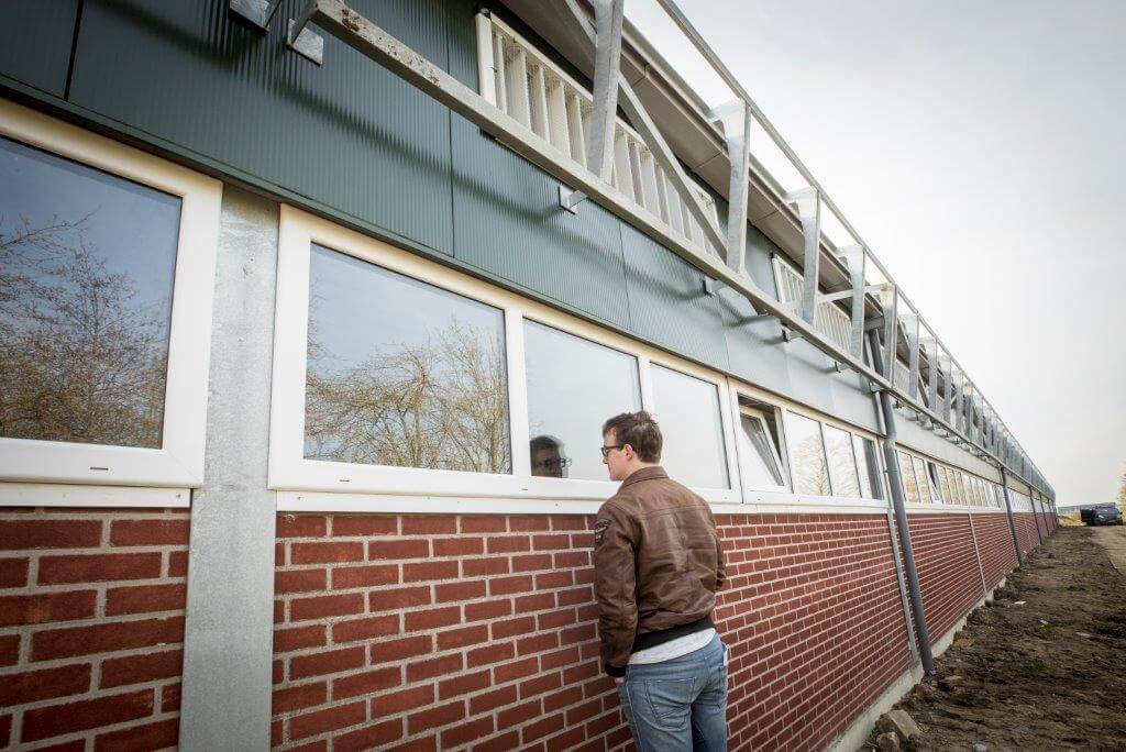 Aan de schaduwzijde van de stal komt nog een winddrukkap voor de luchtinlaat. Lamellen regelen de inlaatopeningen op basis van onderdruk. Via de ramen zijn de kraamafdelingen en de afdelingen voor gespeende biggen en vleesvarkens van buitenaf te bezichtigen. 