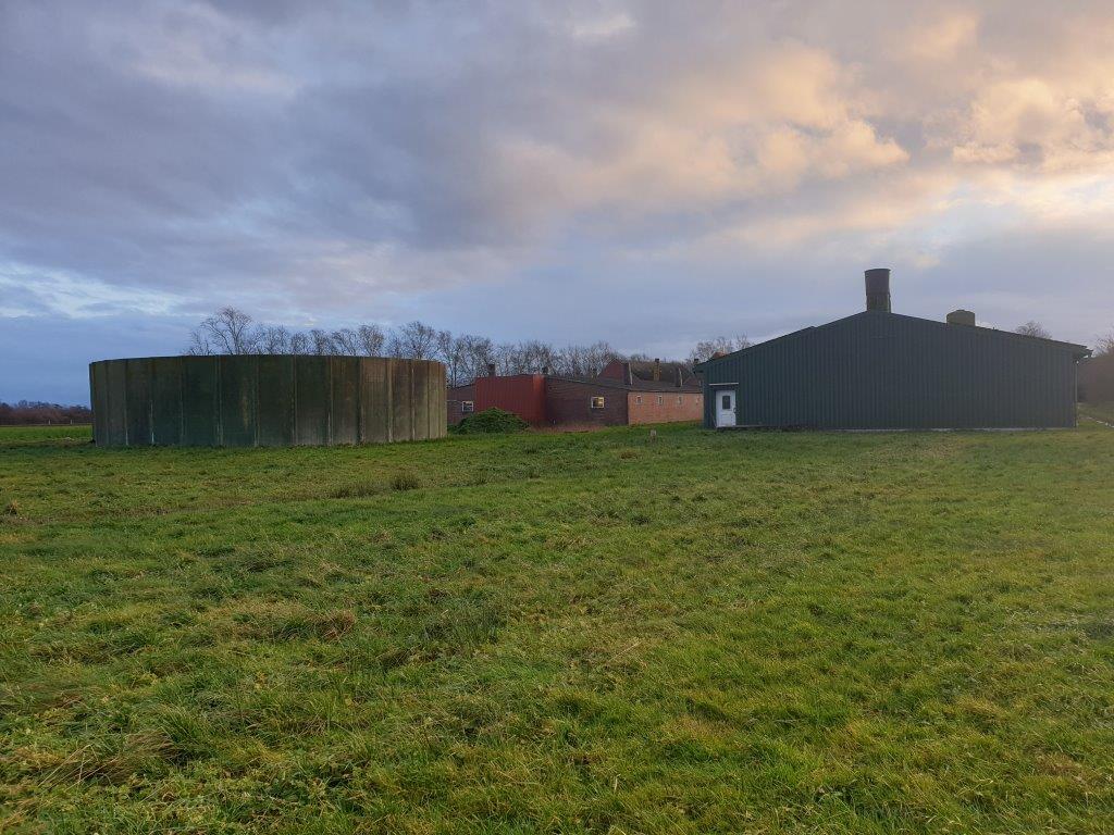 Links achter de mestsilo staat de stal voor de dragende zeugen. In de stal rechts zitten de gespeende biggen. 