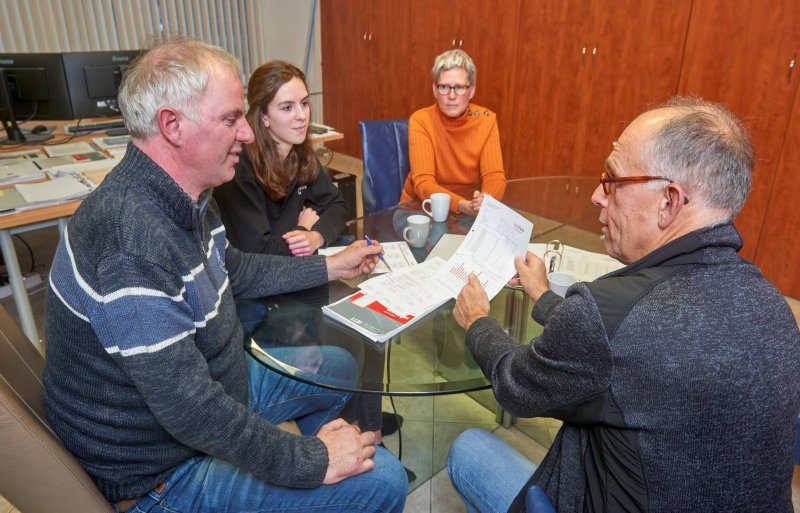 Ricus en Lisa Kuunders kijken samen met dierenarts Chris Schouten en Marlies Olde Monnikhof van Ceva Santé Animale naar de uitslagen van de griepmonsters.