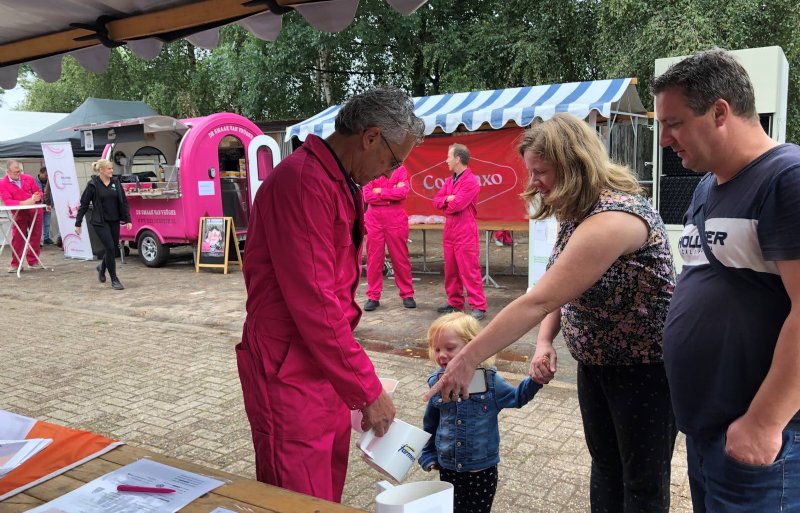 Even kijken wat er in voer van varkens zit. Op de achtergrond de roze foodtruck van Heyde Hoeve.