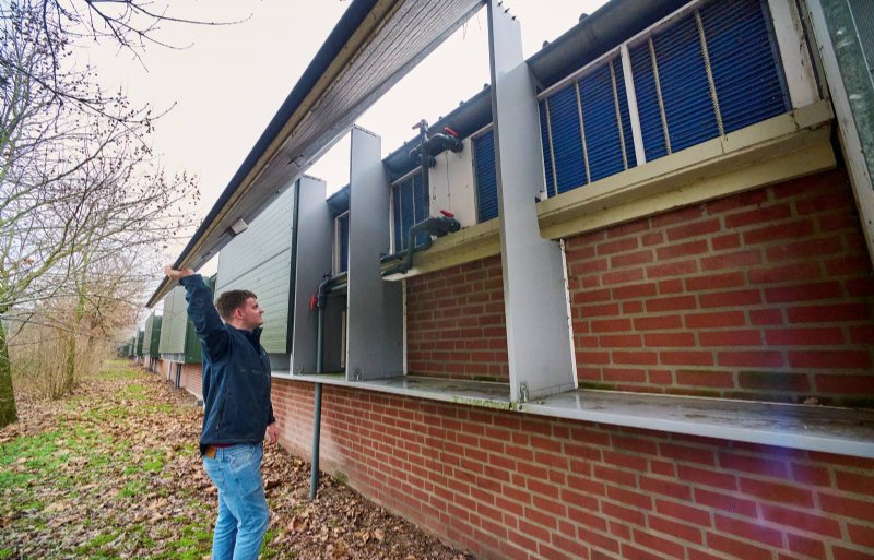 Giedo Steeghs bij luchtinlaat en warmtewisselaar buiten voor biggenstal.