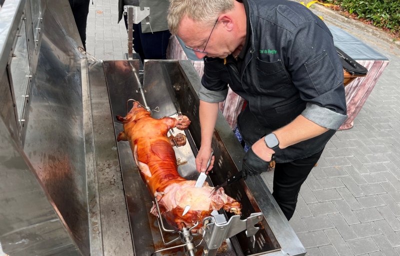 Krokante big aan het spit van Pigarné wordt door een cateraar aangesneden en uitgeserveerd aan de bezoekers van de open dag.
